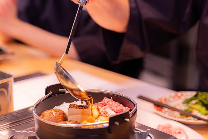 Japanese Sake Tasting & Wagyu Sukiyaki Cooking Class in Tokyo - Eating the hot pot with sake